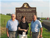 People standing in front of the historical marker