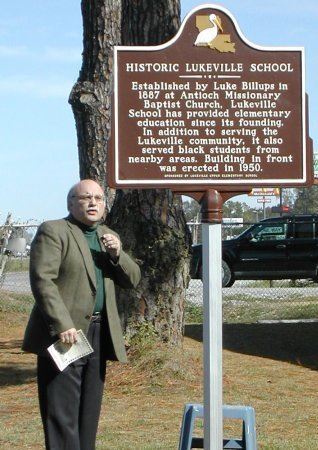 Man talking in front of the historical marker